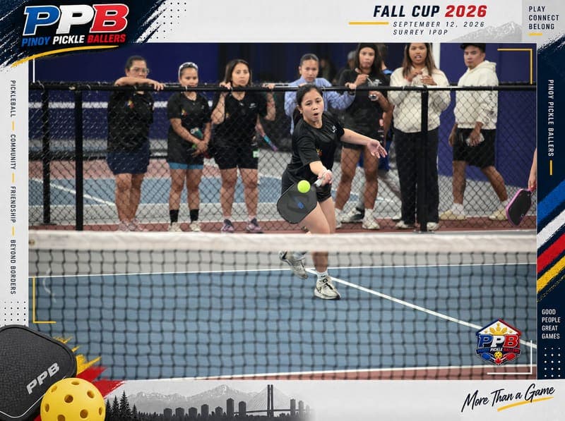 A player lunges at full stretch for a low ball at the net while spectators watch from behind the fence.